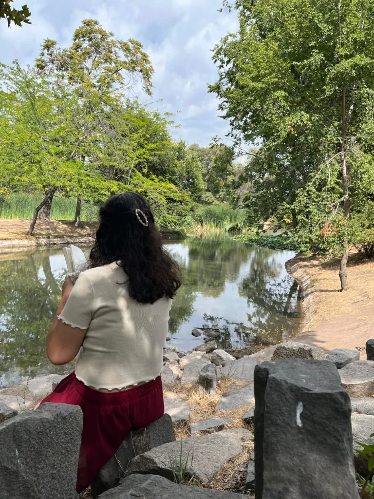Sentada en las piedras, con un libro